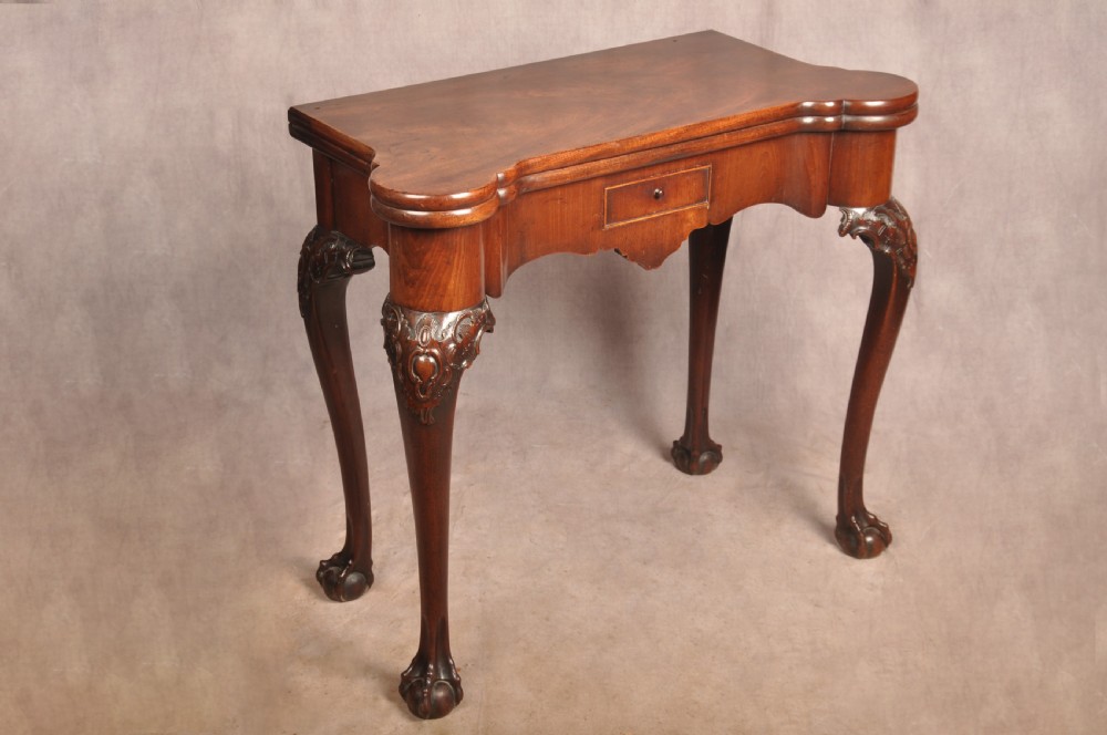 An 18th-century George II mahogany card table with a fold-over shaped top, a frieze drawer, and carved cabriole legs with claw-and-ball feet. View III