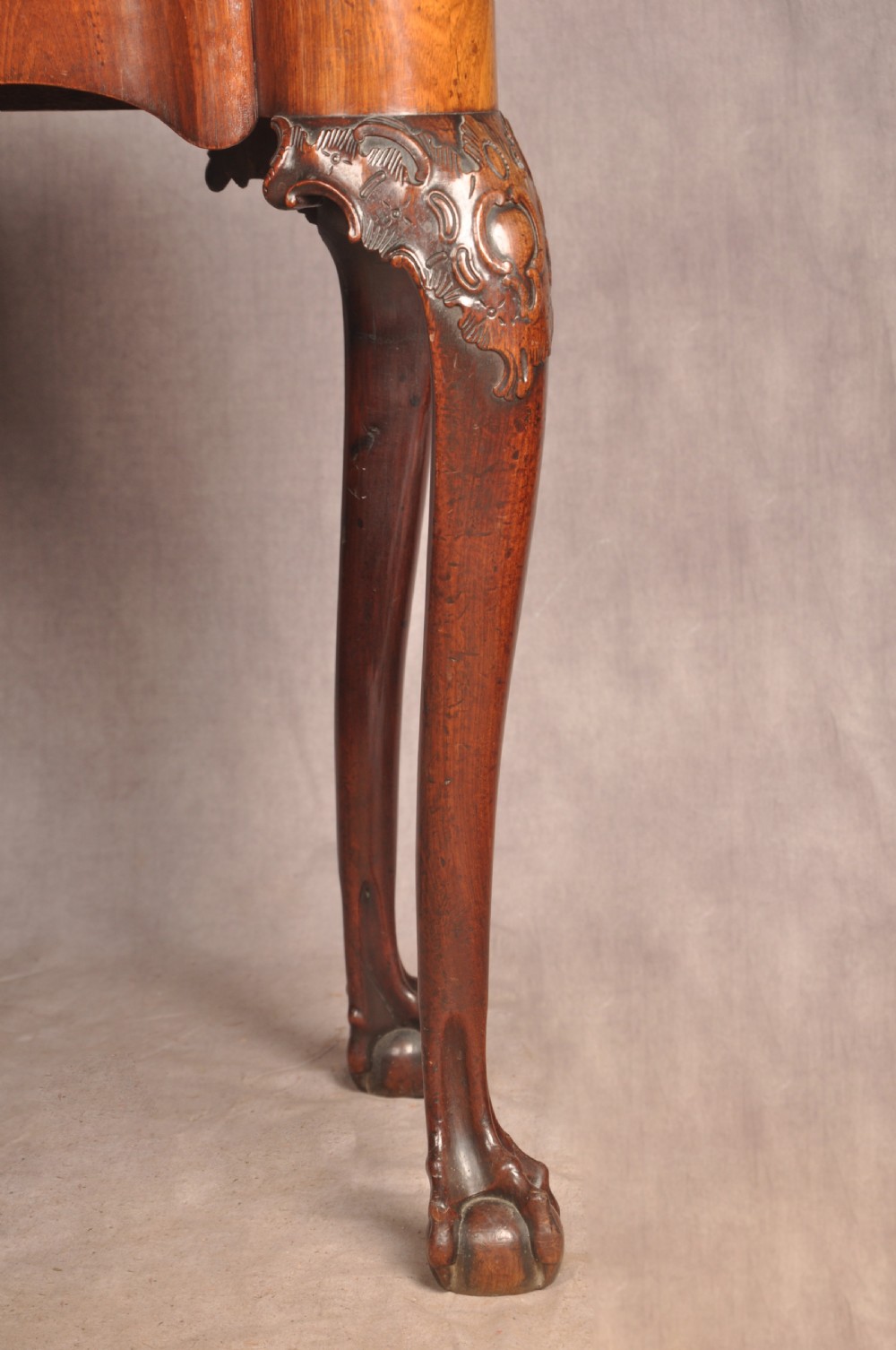 An 18th-century George II mahogany card table with a fold-over shaped top, a frieze drawer, and carved cabriole legs with claw-and-ball feet. View V