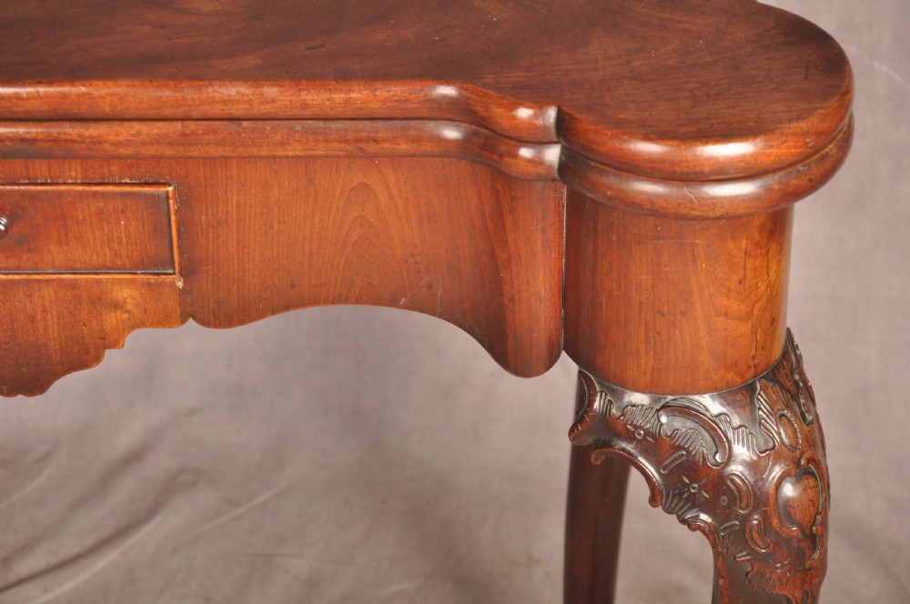 An 18th-century George II mahogany card table with a fold-over shaped top, a frieze drawer, and carved cabriole legs with claw-and-ball feet. View IX
