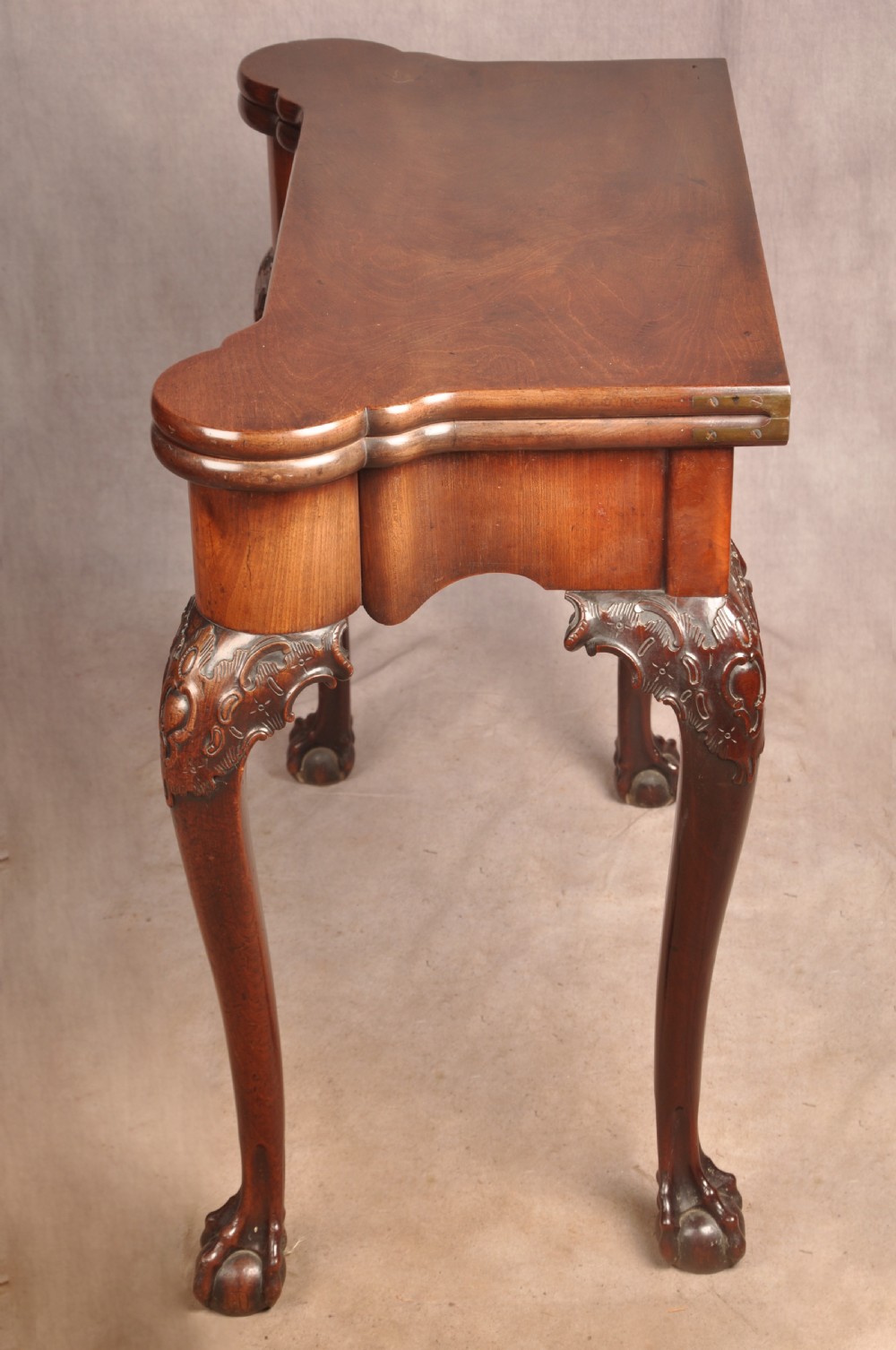 An 18th-century George II mahogany card table with a fold-over shaped top, a frieze drawer, and carved cabriole legs with claw-and-ball feet. View XII