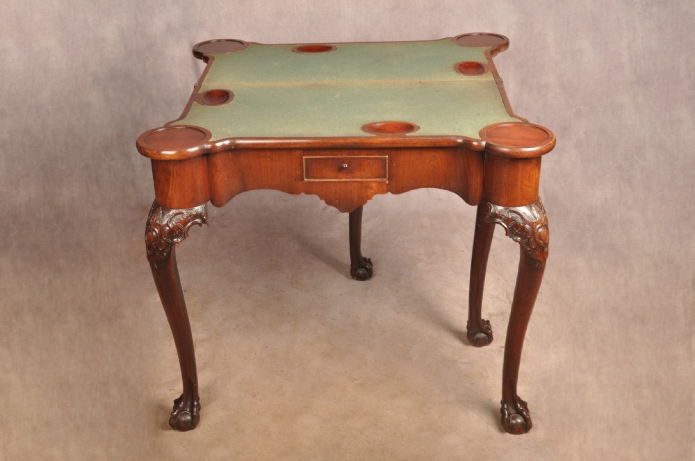 An 18th-century George II mahogany card table with a fold-over shaped top, a frieze drawer, and carved cabriole legs with claw-and-ball feet. View XIV