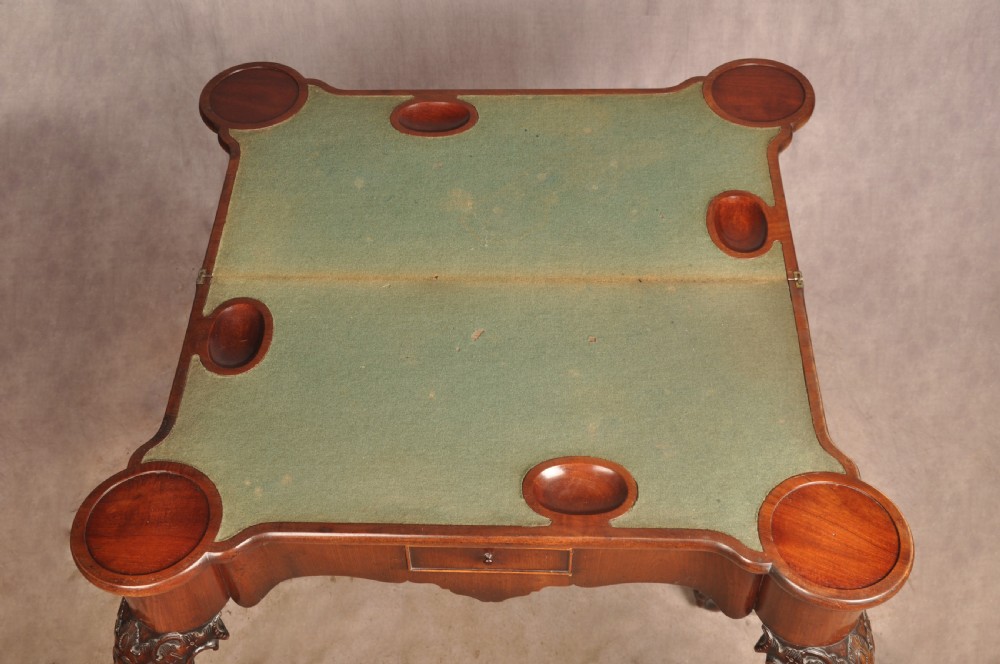 An 18th-century George II mahogany card table with a fold-over shaped top, a frieze drawer, and carved cabriole legs with claw-and-ball feet. View XV
