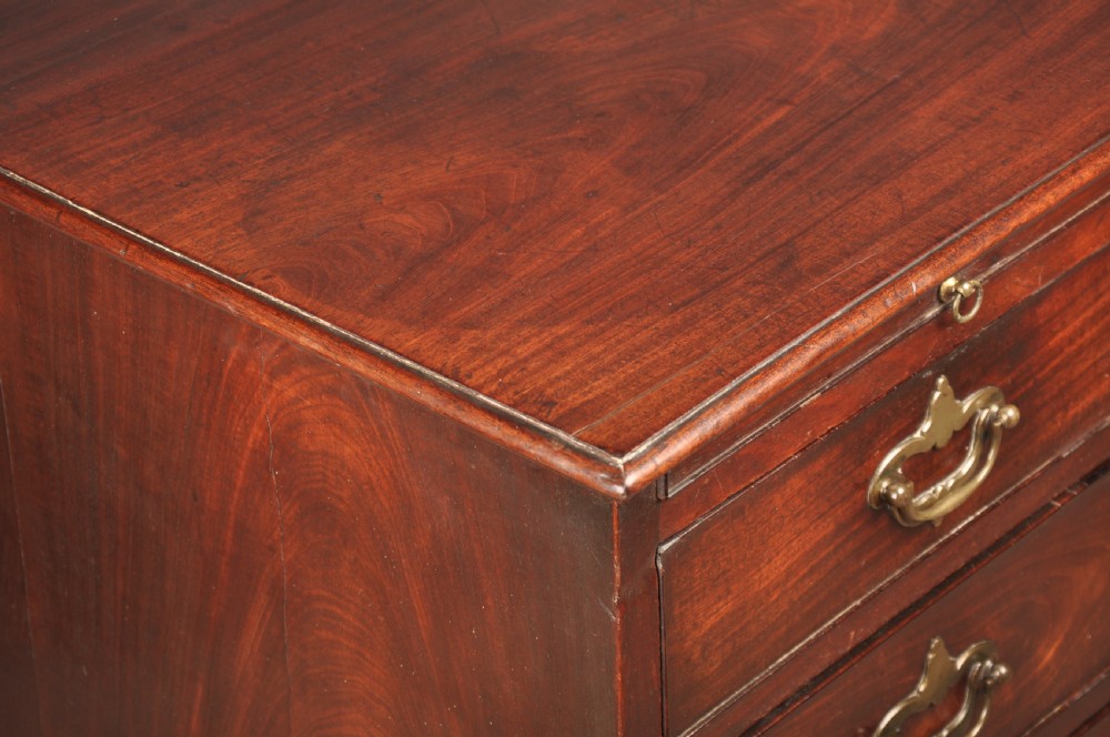 An early eighteenth-century mahogany chest of drawers featuring four graduated drawers, brass handles, a brushing slide, and bracket feet. View III