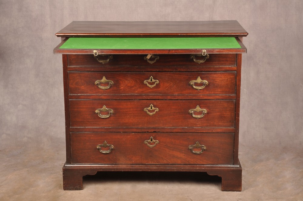 An early eighteenth-century mahogany chest of drawers featuring four graduated drawers, brass handles, a brushing slide, and bracket feet. View VI