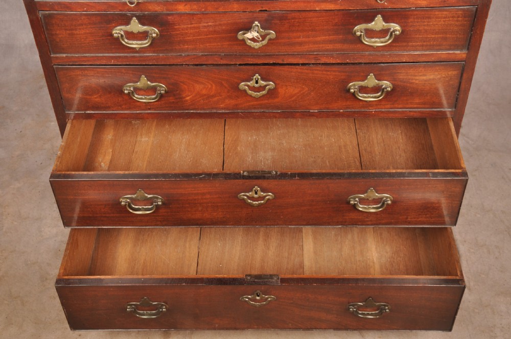 An early eighteenth-century mahogany chest of drawers featuring four graduated drawers, brass handles, a brushing slide, and bracket feet. View VII