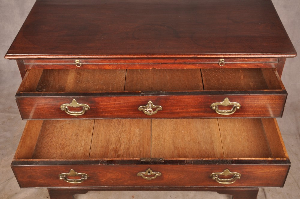 An early eighteenth-century mahogany chest of drawers featuring four graduated drawers, brass handles, a brushing slide, and bracket feet. View VIII