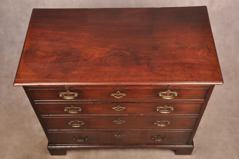 An early eighteenth-century mahogany chest of drawers featuring four graduated drawers, brass handles, a brushing slide, and bracket feet. View XII