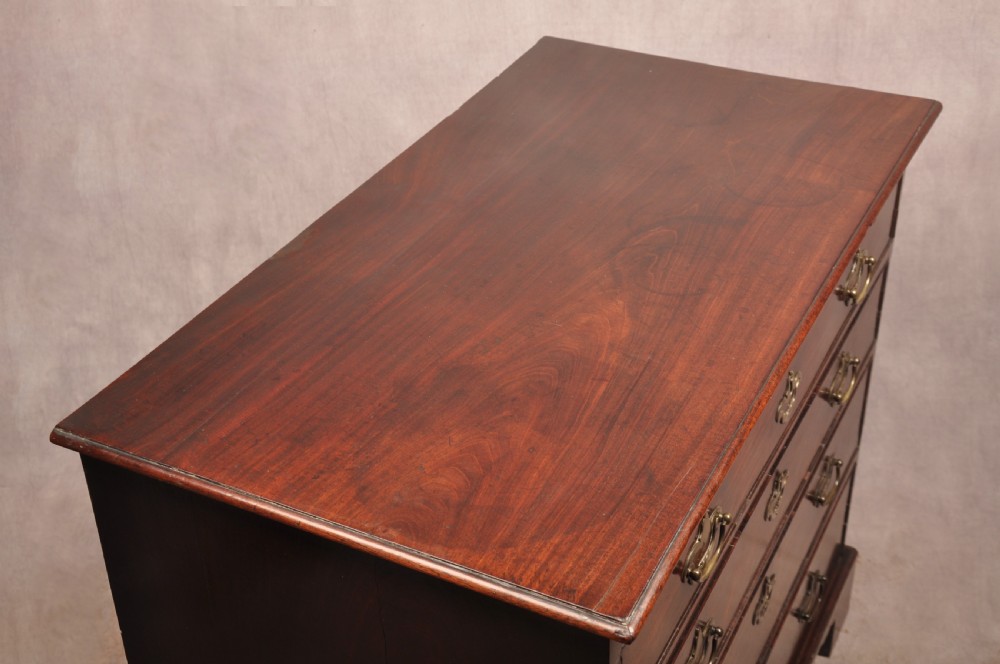 An early eighteenth-century mahogany chest of drawers featuring four graduated drawers, brass handles, a brushing slide, and bracket feet. View XIII