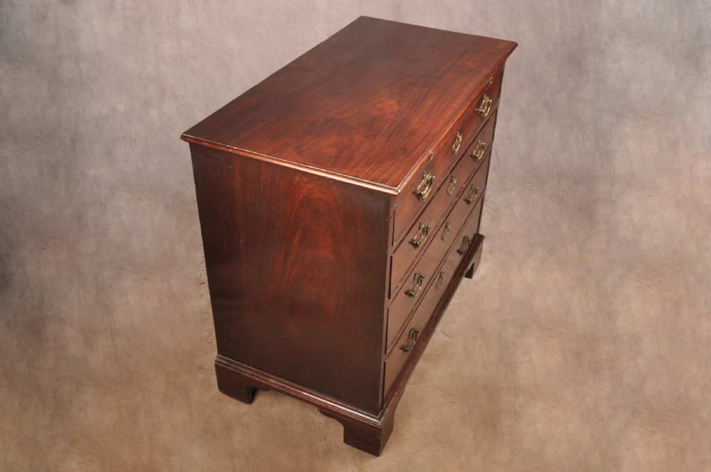 An early eighteenth-century mahogany chest of drawers featuring four graduated drawers, brass handles, a brushing slide, and bracket feet. View XIV