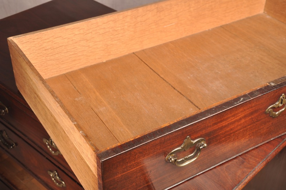 An early eighteenth-century mahogany chest of drawers featuring four graduated drawers, brass handles, a brushing slide, and bracket feet. View XV