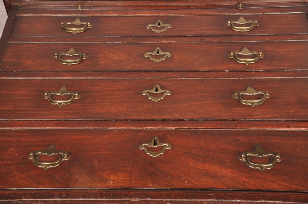 An early eighteenth-century mahogany chest of drawers featuring four graduated drawers, brass handles, a brushing slide, and bracket feet. View XX