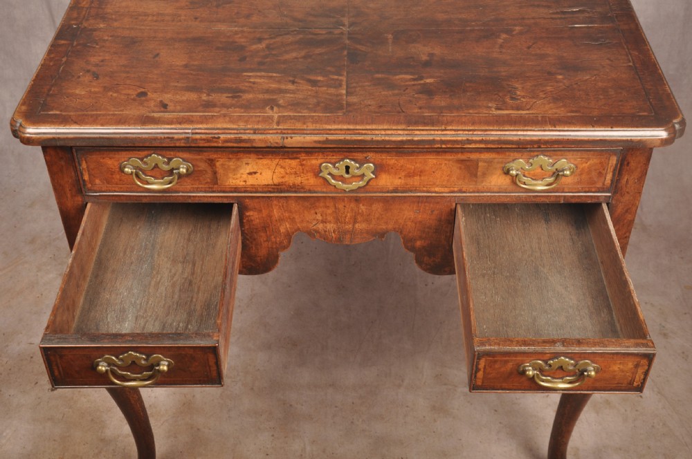 An 18th-century George II walnut lowboy side table featuring three drawers with brass handles, a shaped kneehole apron, and cabriole legs on pad feet. View II