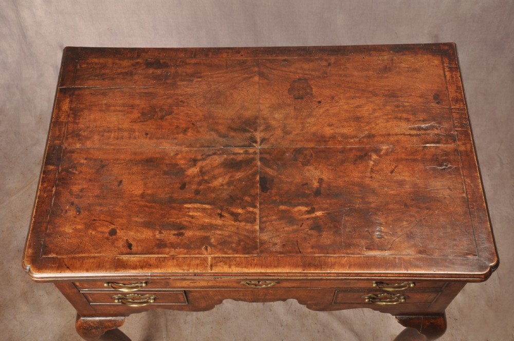 An 18th-century George II walnut lowboy side table featuring three drawers with brass handles, a shaped kneehole apron, and cabriole legs on pad feet. View III