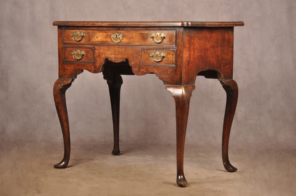 An 18th-century George II walnut lowboy side table featuring three drawers with brass handles, a shaped kneehole apron, and cabriole legs on pad feet. View XII
