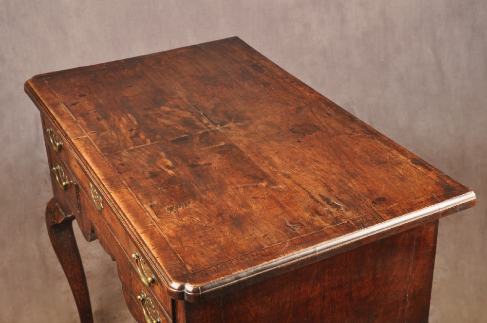An 18th-century George II walnut lowboy side table featuring three drawers with brass handles, a shaped kneehole apron, and cabriole legs on pad feet. View XIII