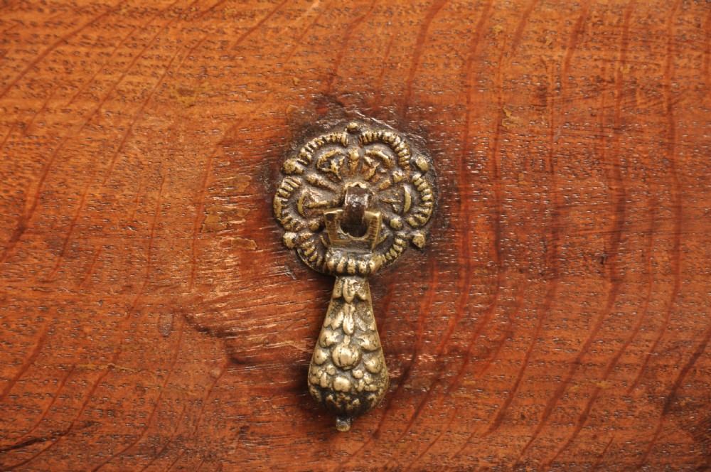 A 17th-century Charles II solid oak chest of drawers featuring geometric applied mouldings and brass teardrop handles. View XII