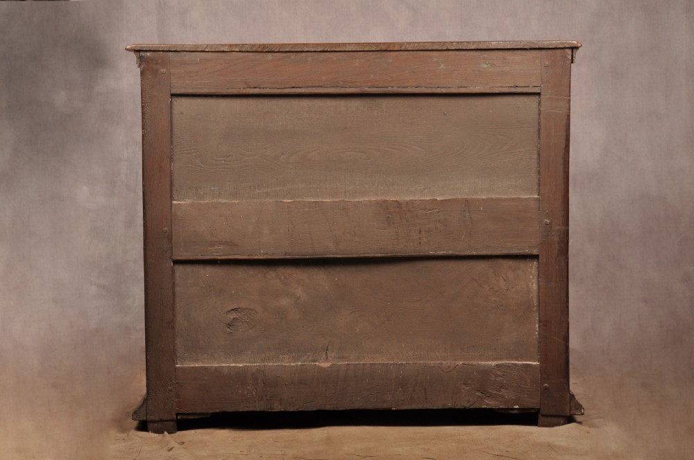 A 17th-century Charles II solid oak chest of drawers featuring geometric applied mouldings and brass teardrop handles. View XIII