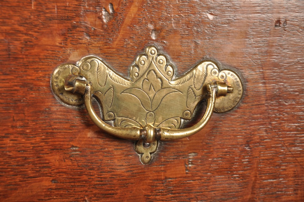 An 18th-century George I oak chest on stand featuring multiple graduated drawers with brass handles, resting on shaped cabriole legs. View II
