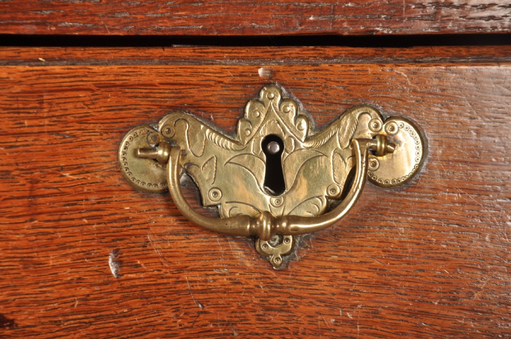 An 18th-century George I oak chest on stand featuring multiple graduated drawers with brass handles, resting on shaped cabriole legs. View III