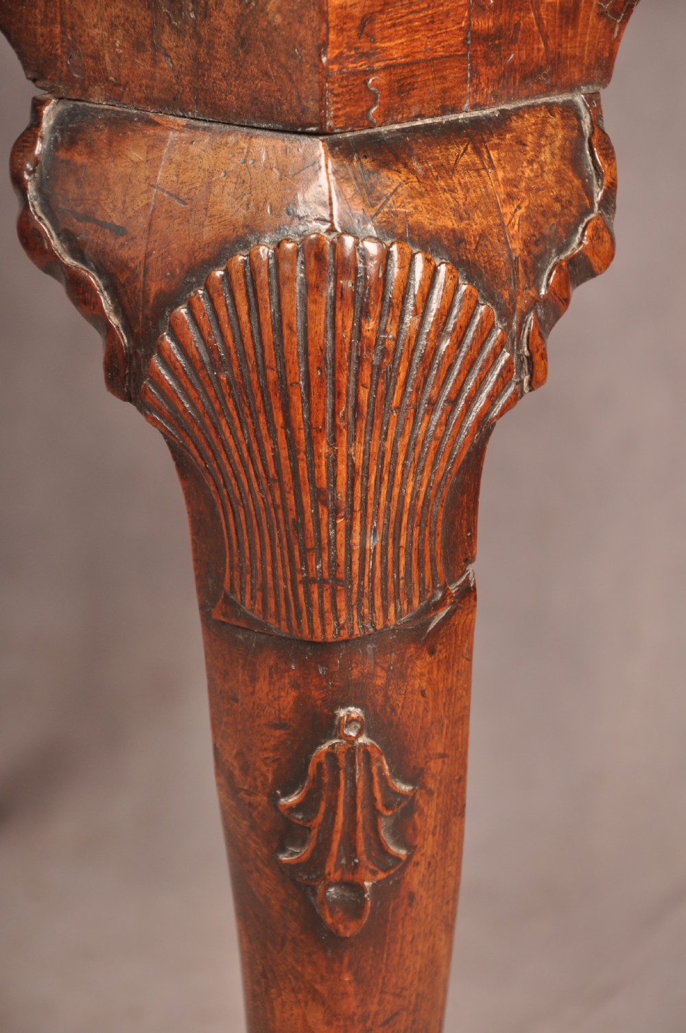 An early 18th century walnut lowboy featuring three drawers with brass handles, a shaped apron, and shell-carved cabriole legs. View III