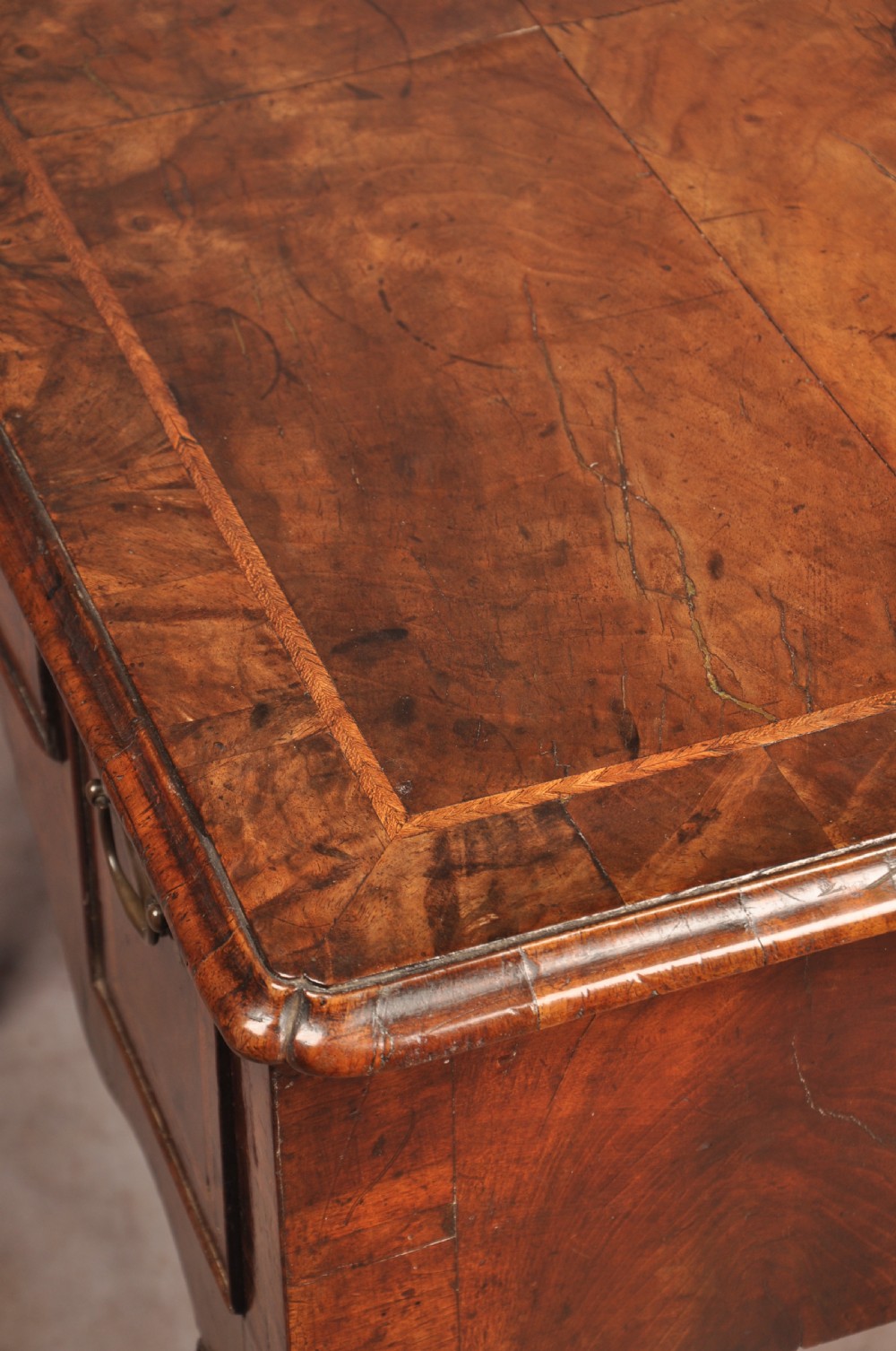 An early 18th century walnut lowboy featuring three drawers with brass handles, a shaped apron, and shell-carved cabriole legs. View XIII