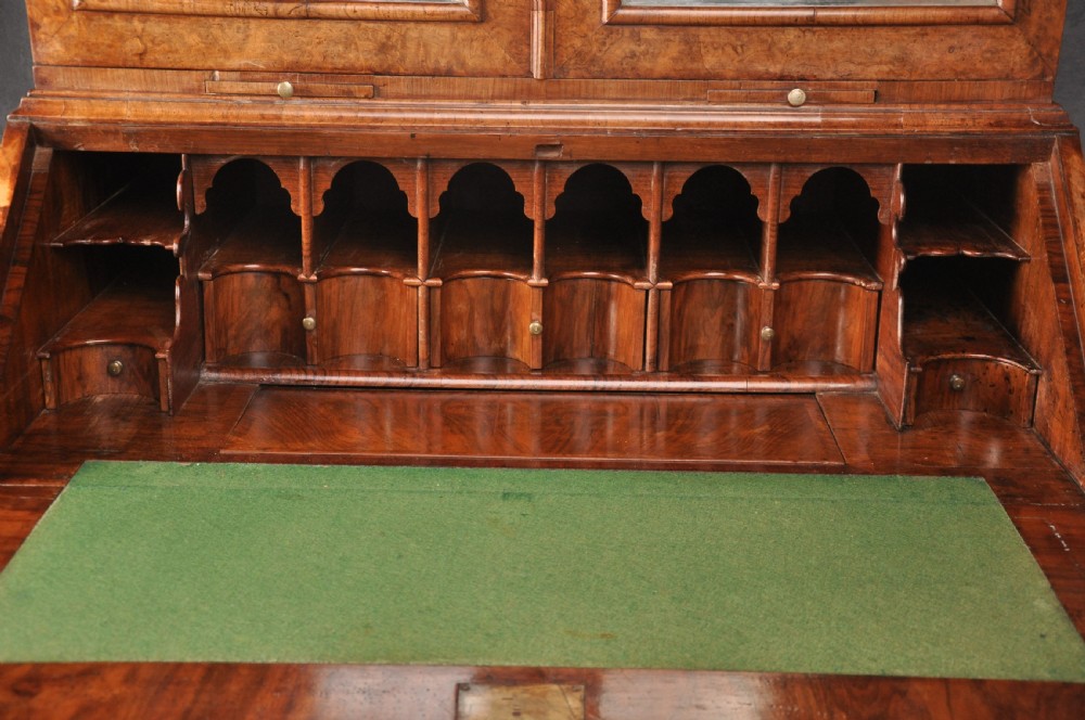 A 17th-century burr walnut bureau cabinet featuring double arched mirrored doors above a slant-front writing desk and drawers on compressed bun feet. View VII
