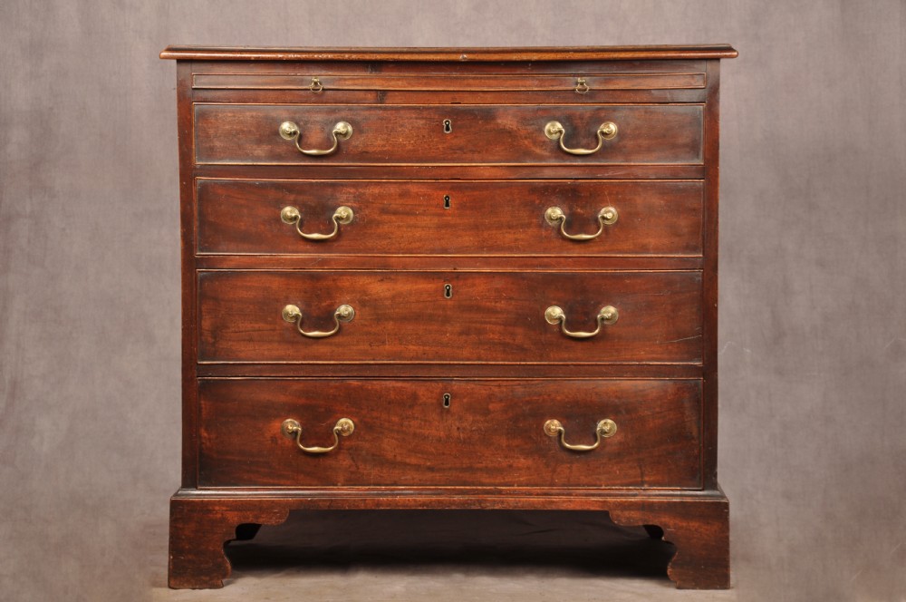 An eighteenth-century mahogany chest of drawers featuring four graduated drawers with brass swan-neck handles, a brushing slide, and bracket feet. View III