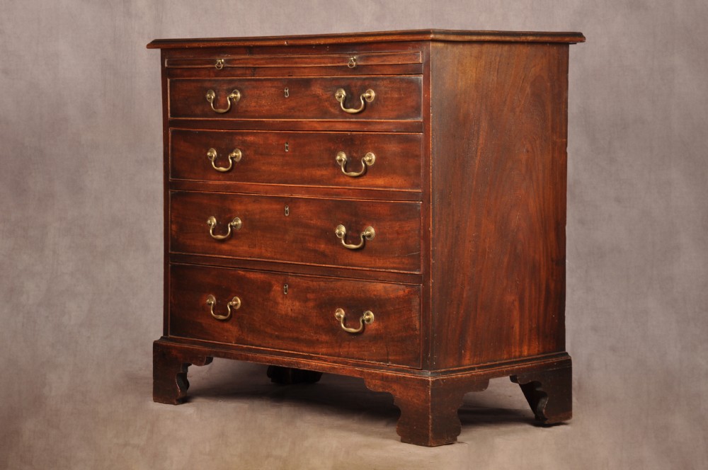 An eighteenth-century mahogany chest of drawers featuring four graduated drawers with brass swan-neck handles, a brushing slide, and bracket feet. View II