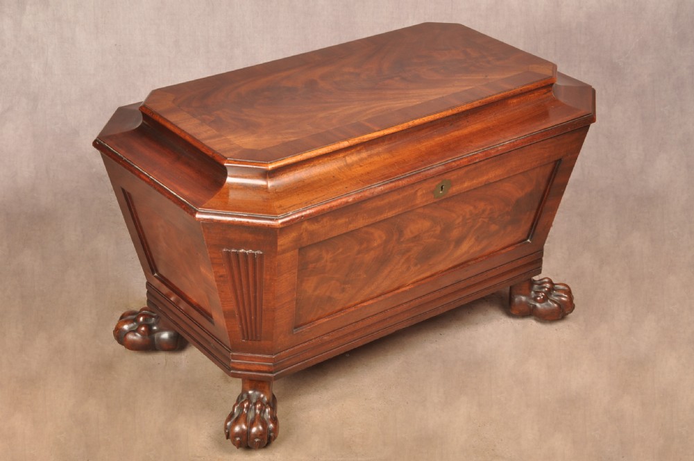 A Regency flame mahogany sarcophagus-shaped wine cooler featuring a hinged stepped lid, reeded corners, and carved paw feet. View II