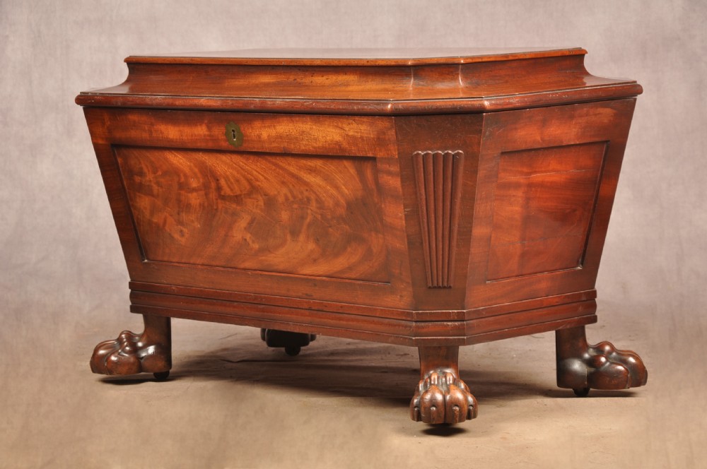 A Regency flame mahogany sarcophagus-shaped wine cooler featuring a hinged stepped lid, reeded corners, and carved paw feet. View III