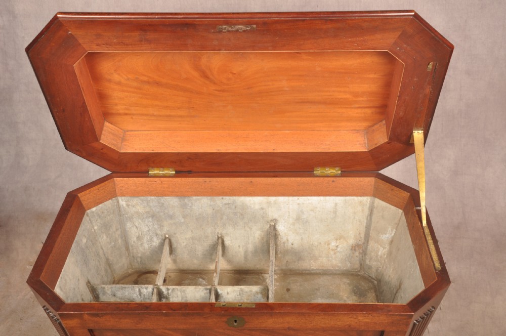 A Regency flame mahogany sarcophagus-shaped wine cooler featuring a hinged stepped lid, reeded corners, and carved paw feet. View IX