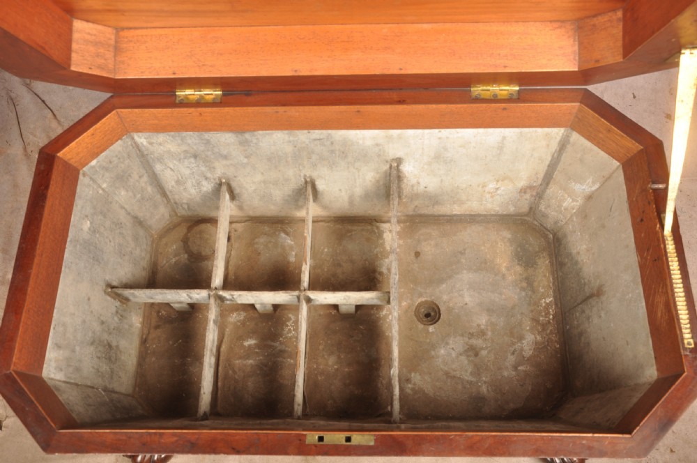 A Regency flame mahogany sarcophagus-shaped wine cooler featuring a hinged stepped lid, reeded corners, and carved paw feet. View X