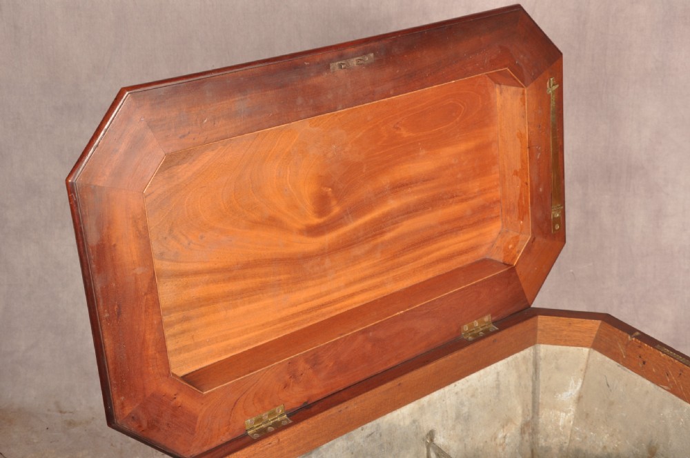 A Regency flame mahogany sarcophagus-shaped wine cooler featuring a hinged stepped lid, reeded corners, and carved paw feet. View XV