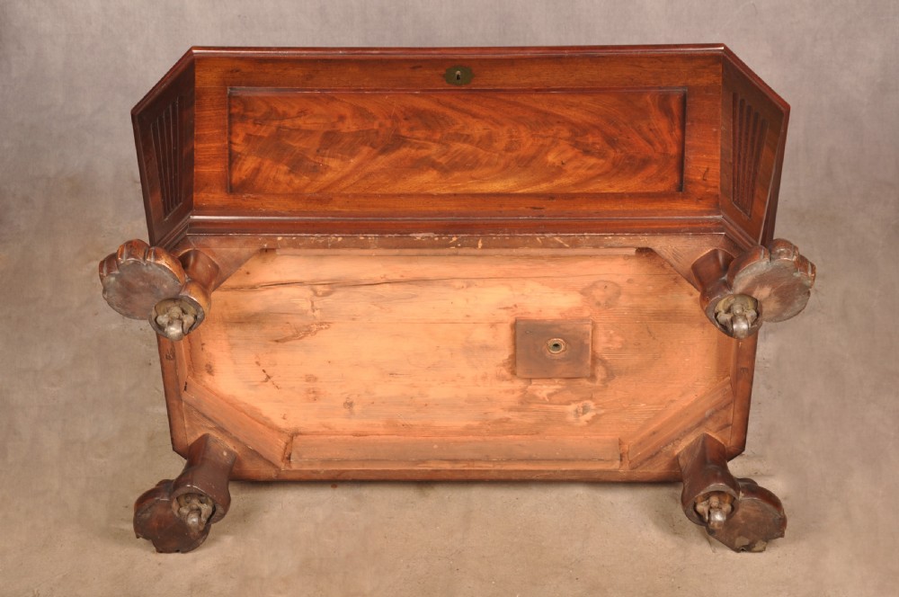 A Regency flame mahogany sarcophagus-shaped wine cooler featuring a hinged stepped lid, reeded corners, and carved paw feet. View XVI