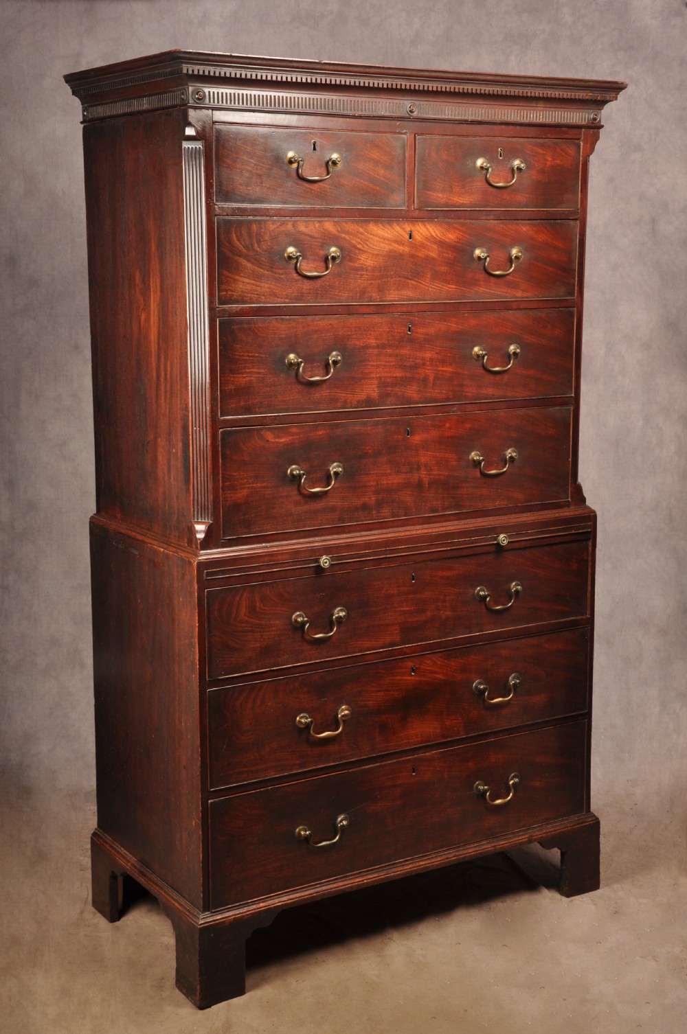 An 18th-century mahogany tallboy featuring stacked upper and lower drawer sections, brass swan-neck handles, fluted sides, and bracket feet. View X
