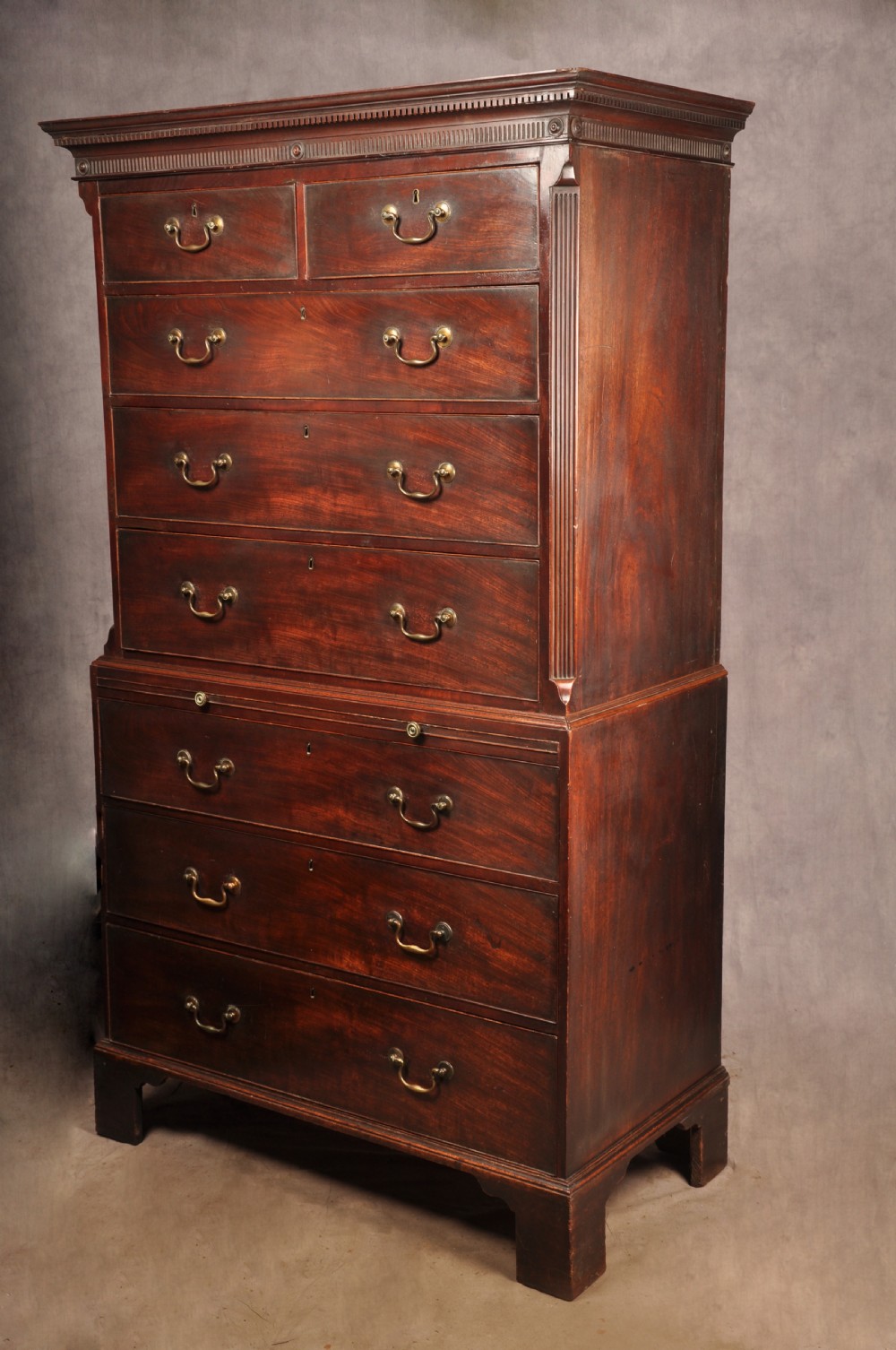 An 18th-century mahogany tallboy featuring stacked upper and lower drawer sections, brass swan-neck handles, fluted sides, and bracket feet. View XI