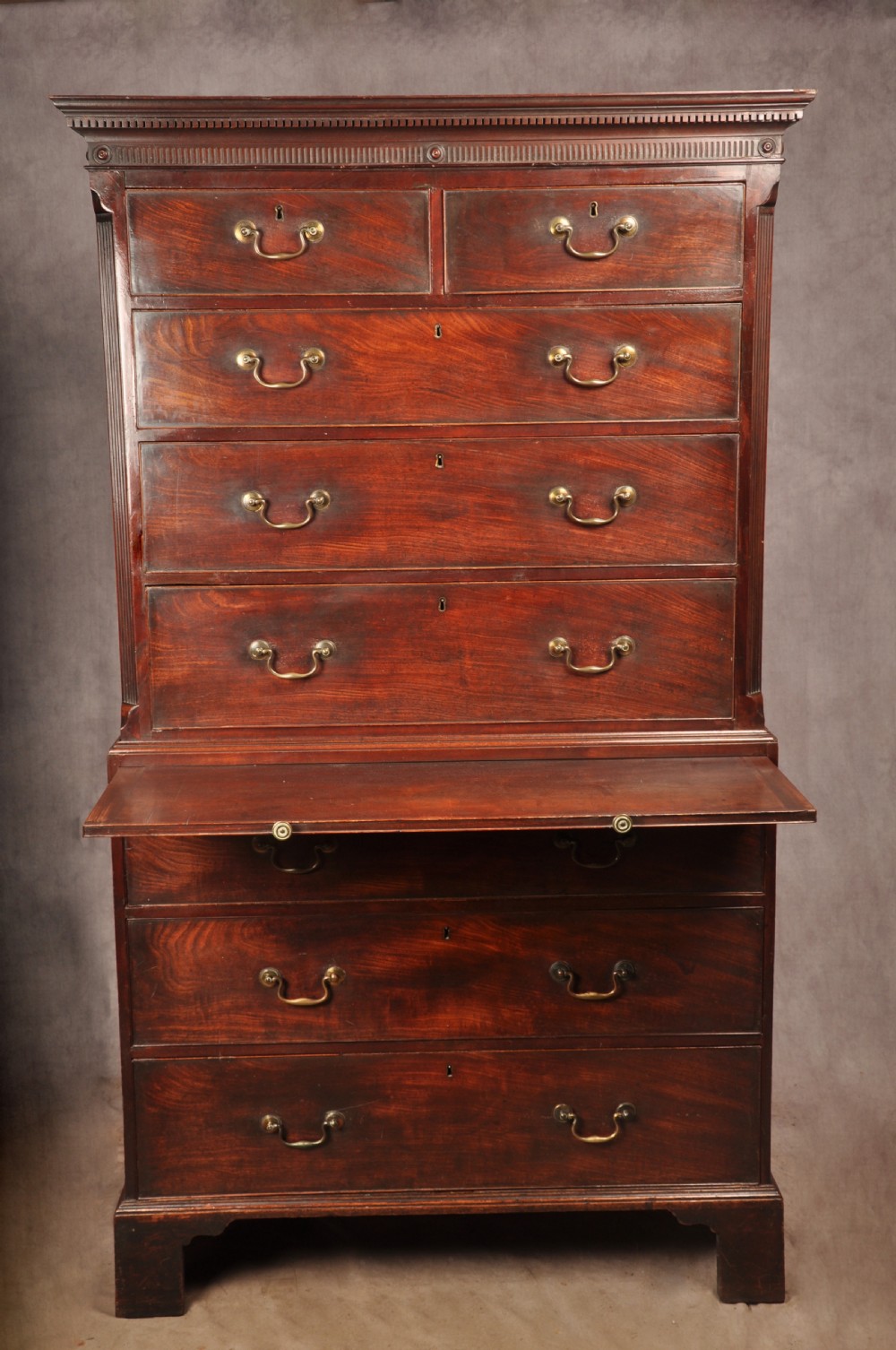 An 18th-century mahogany tallboy featuring stacked upper and lower drawer sections, brass swan-neck handles, fluted sides, and bracket feet. View XII