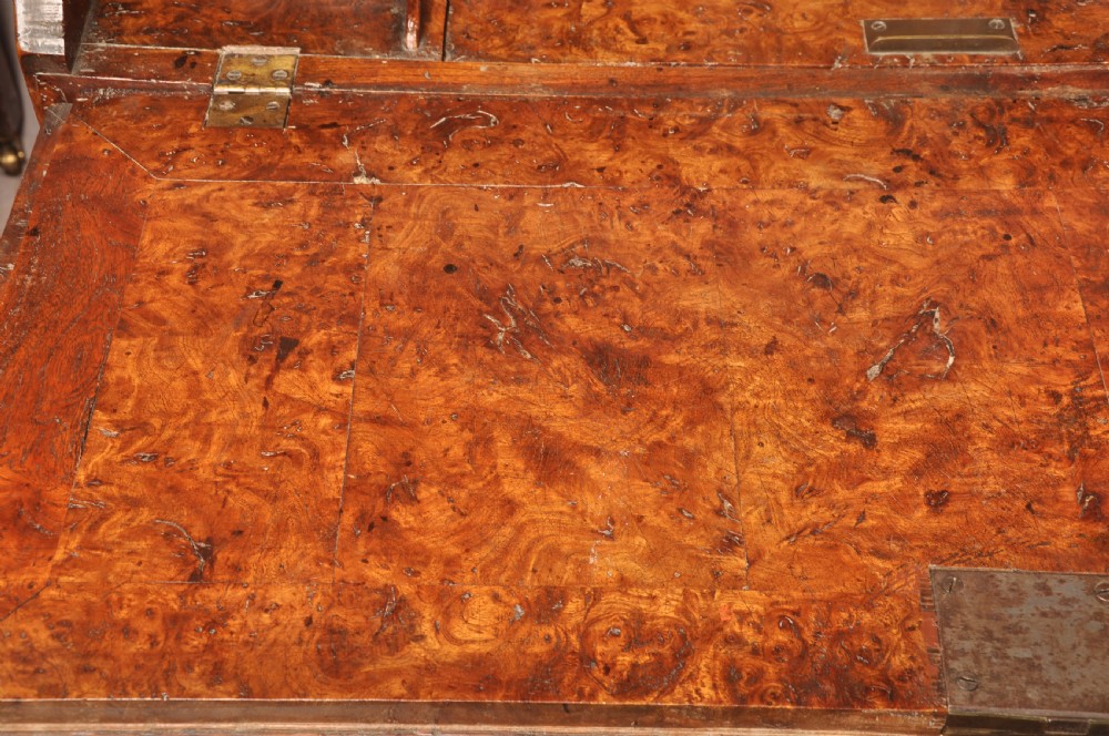 An early 18th-century burr elm slant-front writing bureau featuring figured wood grain, brass drop handles, and bracket feet. View IX