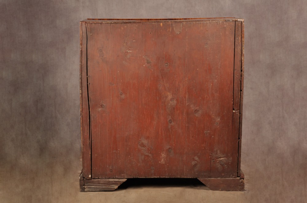 An early 18th-century burr elm slant-front writing bureau featuring figured wood grain, brass drop handles, and bracket feet. View XX