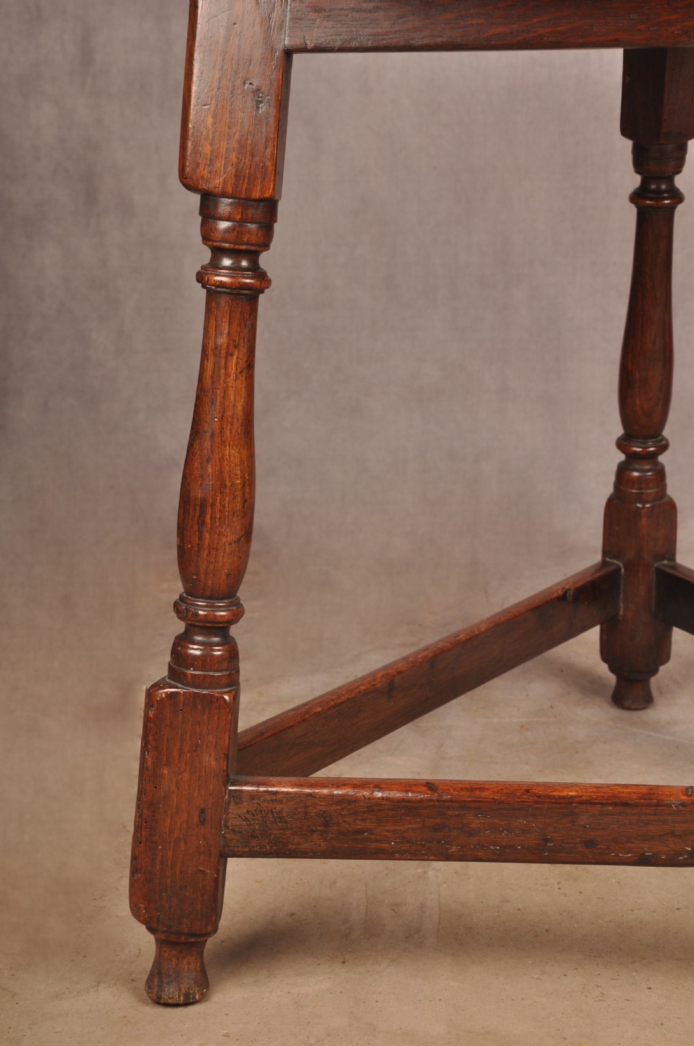 An 18th-century circular timber cricket table with three turned legs connected by a low triangular stretcher. View IV
