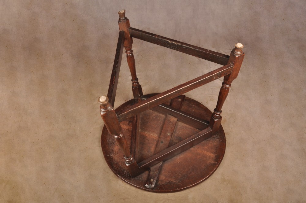 An 18th-century circular timber cricket table with three turned legs connected by a low triangular stretcher. View IX