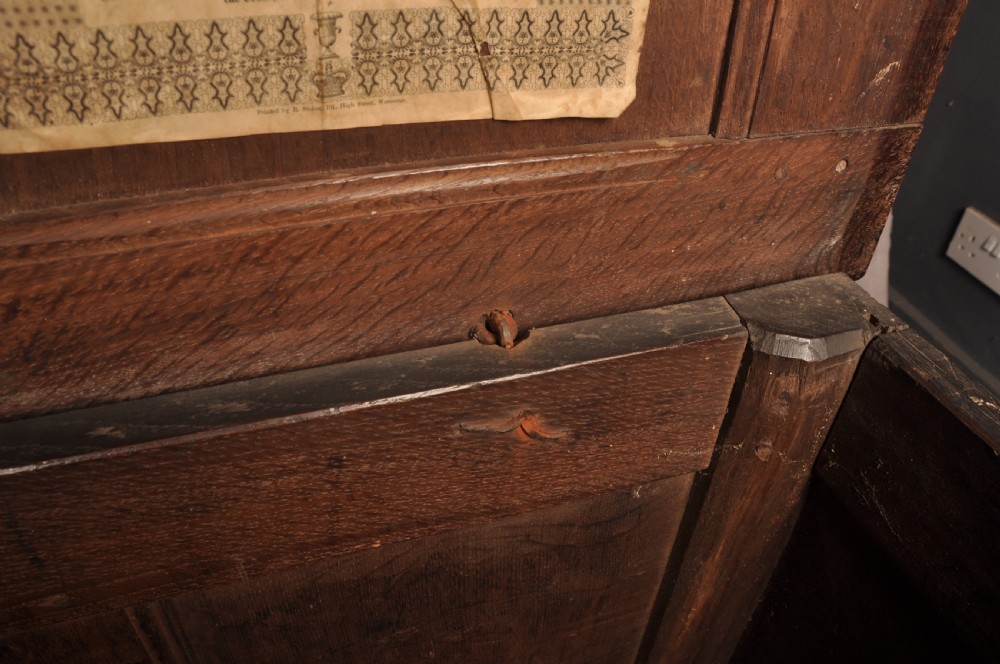 A 17th-century carved dark oak coffer featuring intricate geometric lozenge panels, an arched central carving, and a flat hinged lid. View XI