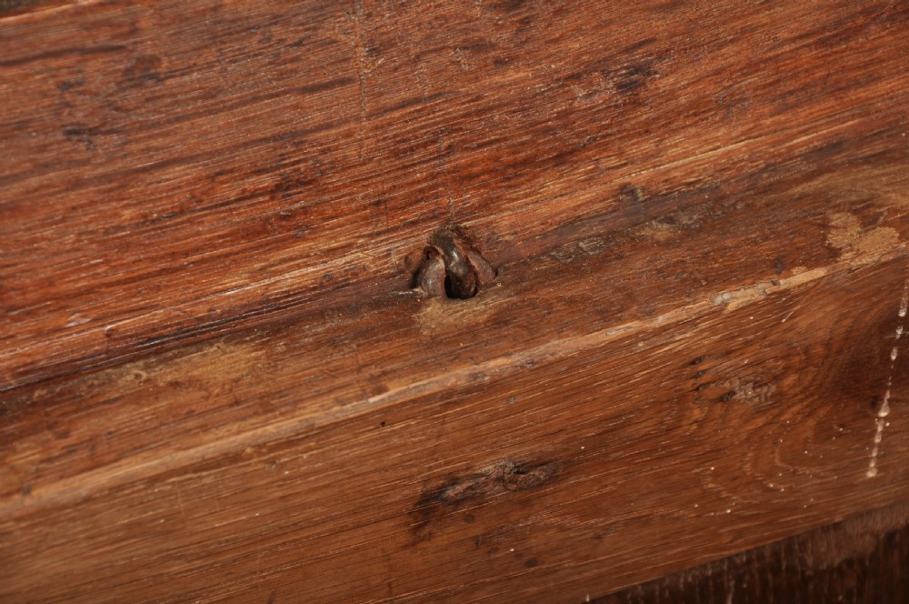 A dark oak 17th-century coffer featuring four carved relief panels, a carved top frieze with an inscribed date, and a hinged lid. View XII