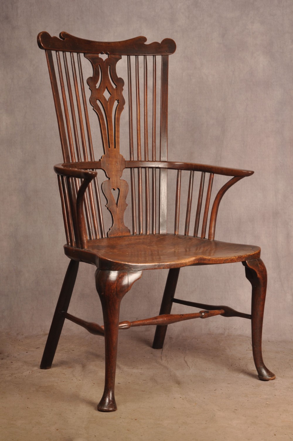 An 18th-century cherrywood Thames Valley Windsor armchair featuring a high comb back, pierced fretwork splat, curved armrests, saddled seat, and cabriole front legs. View III