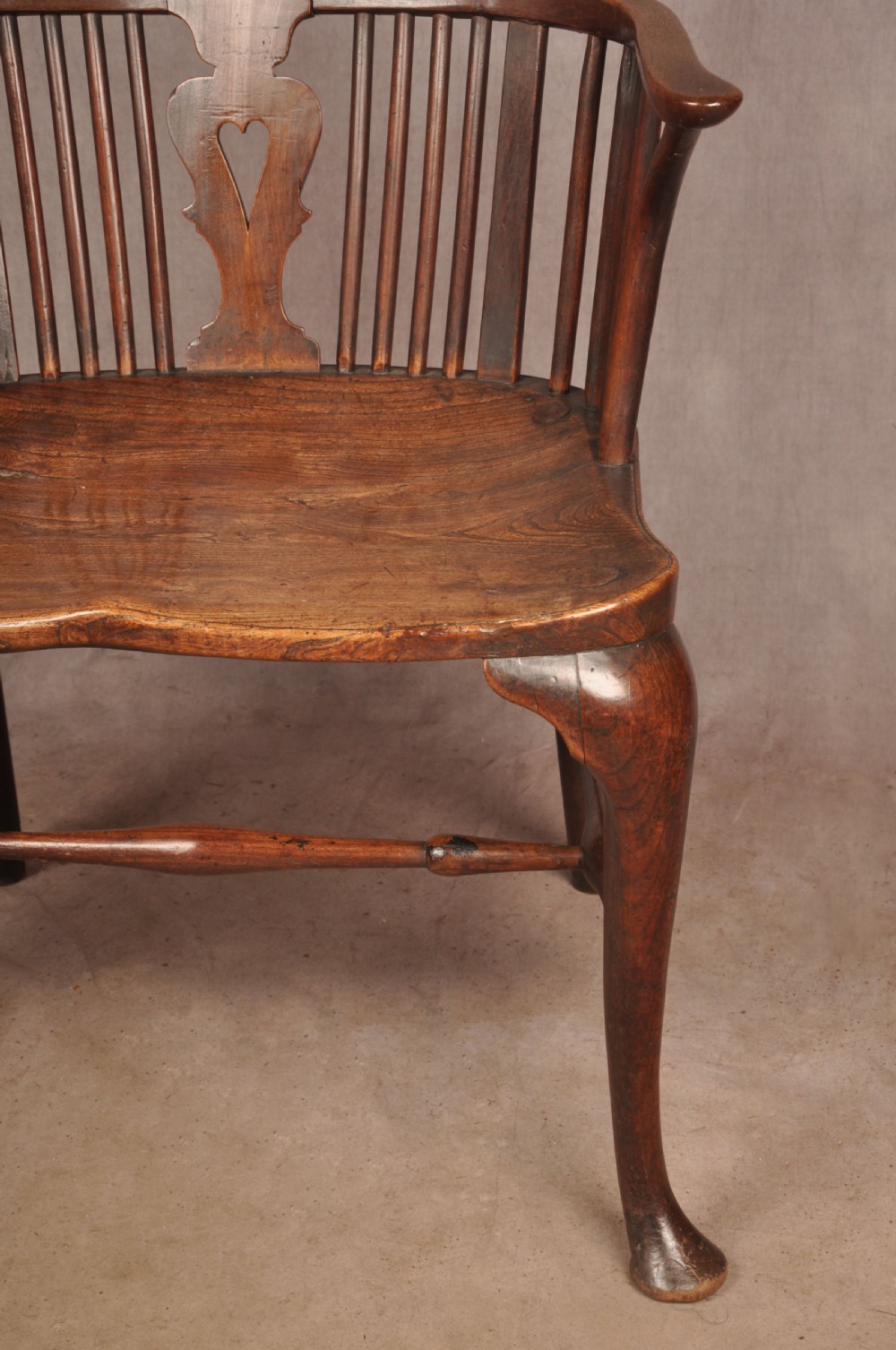 An 18th-century cherrywood Thames Valley Windsor armchair featuring a high comb back, pierced fretwork splat, curved armrests, saddled seat, and cabriole front legs. View VI