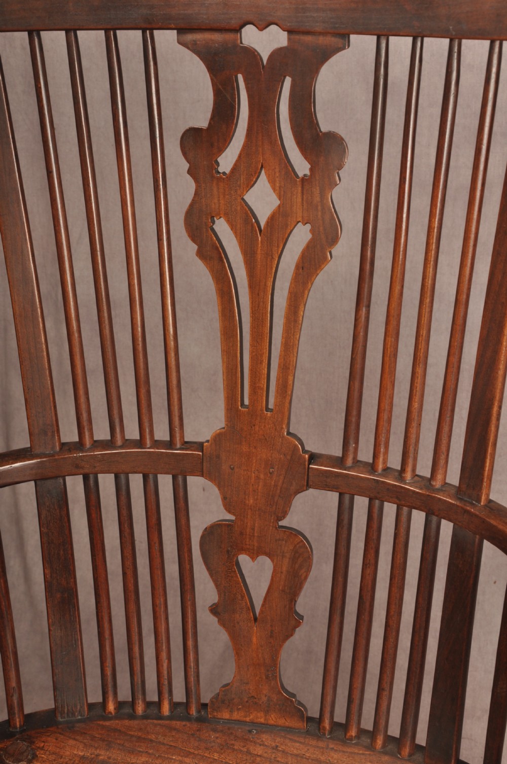 An 18th-century cherrywood Thames Valley Windsor armchair featuring a high comb back, pierced fretwork splat, curved armrests, saddled seat, and cabriole front legs. View XII
