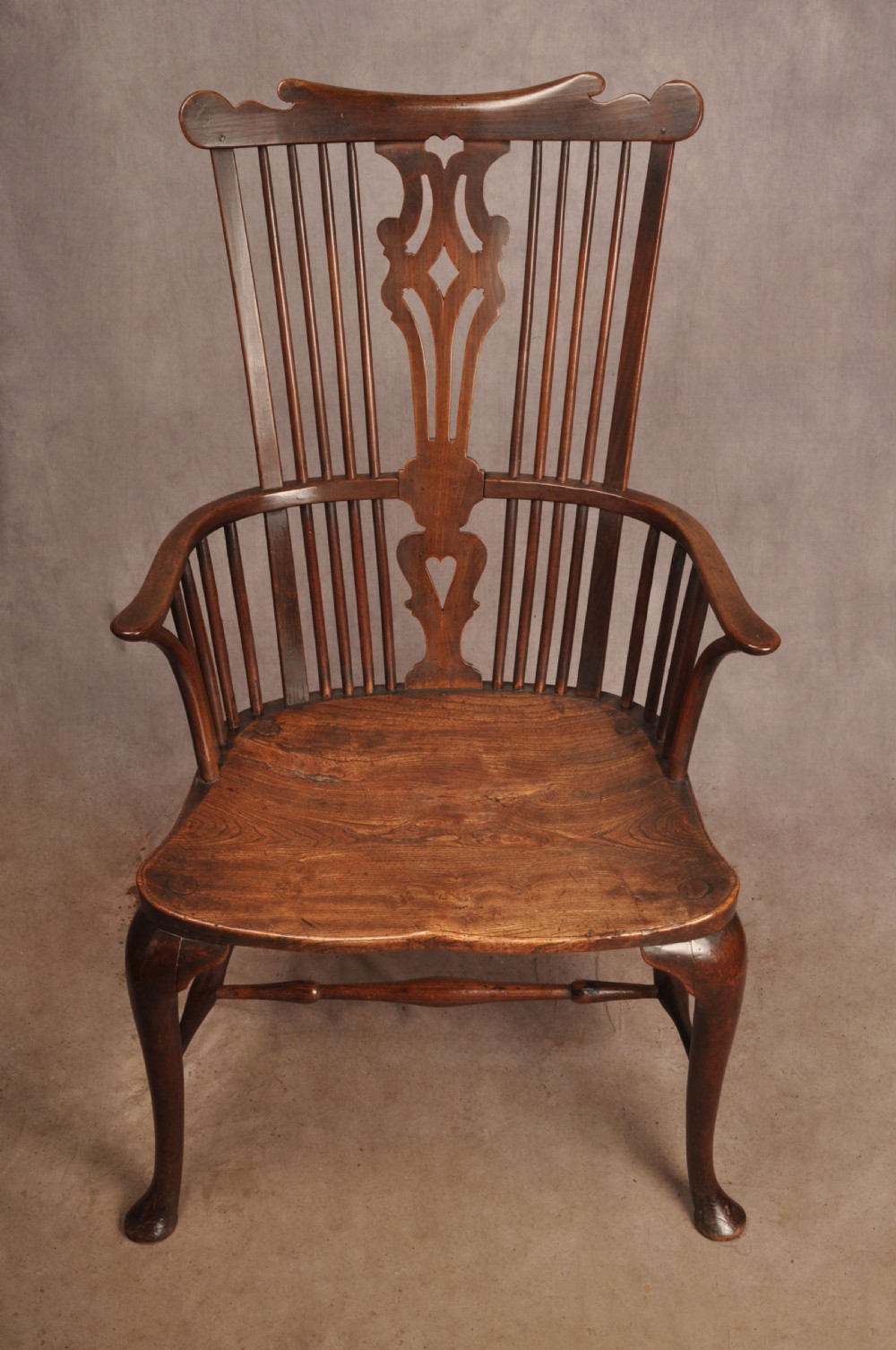 An 18th-century cherrywood Thames Valley Windsor armchair featuring a high comb back, pierced fretwork splat, curved armrests, saddled seat, and cabriole front legs. View XIII