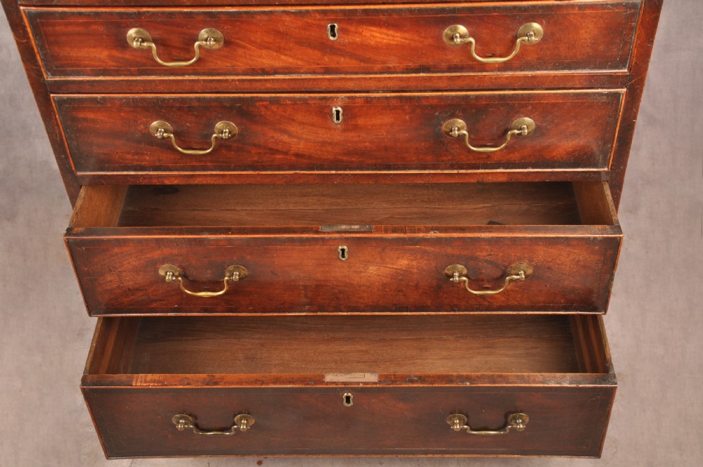 An eighteenth-century Georgian mahogany chest of drawers featuring four graduated drawers with brass swan-neck handles and bracket feet. View II