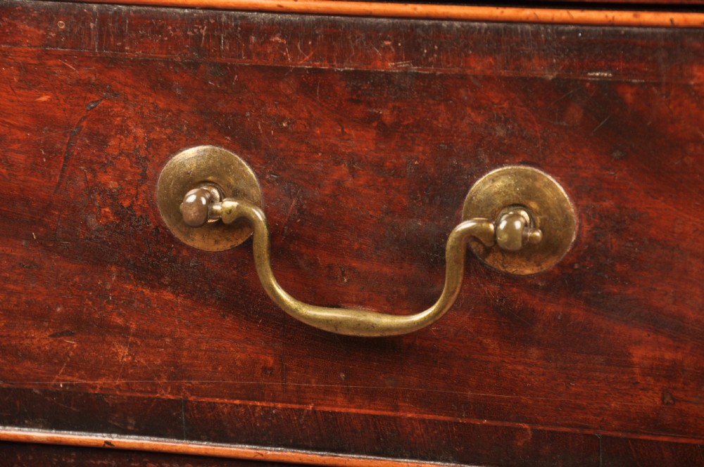 An eighteenth-century Georgian mahogany chest of drawers featuring four graduated drawers with brass swan-neck handles and bracket feet. View V