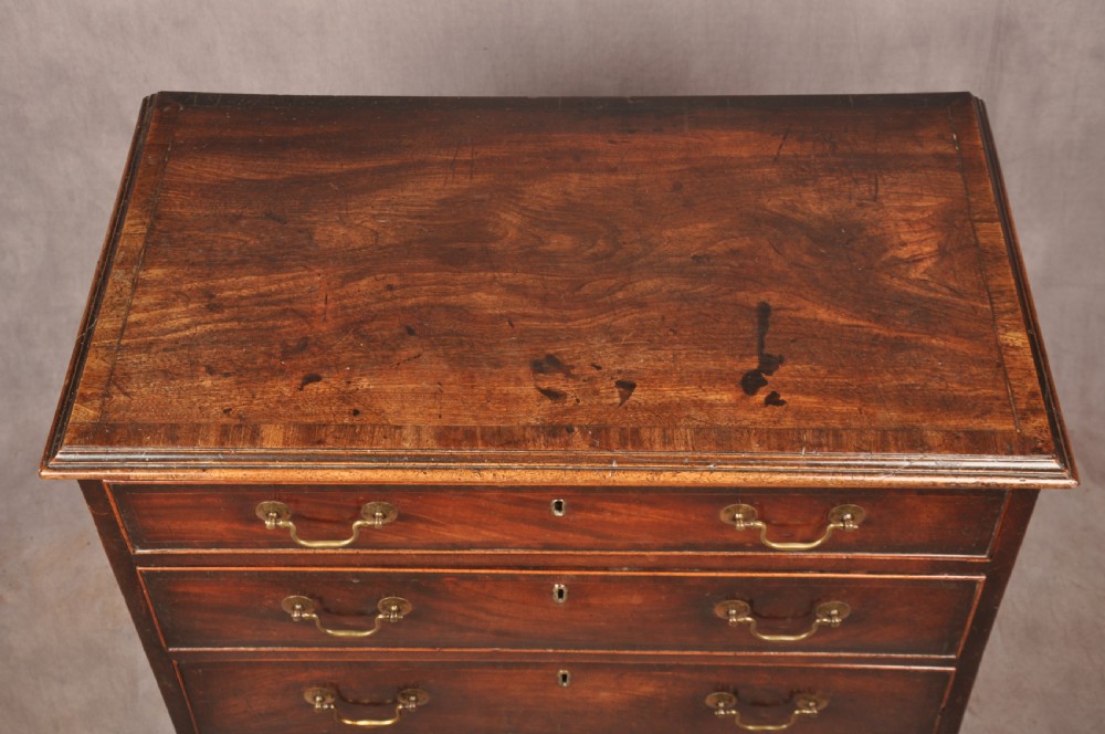 An eighteenth-century Georgian mahogany chest of drawers featuring four graduated drawers with brass swan-neck handles and bracket feet. View VII